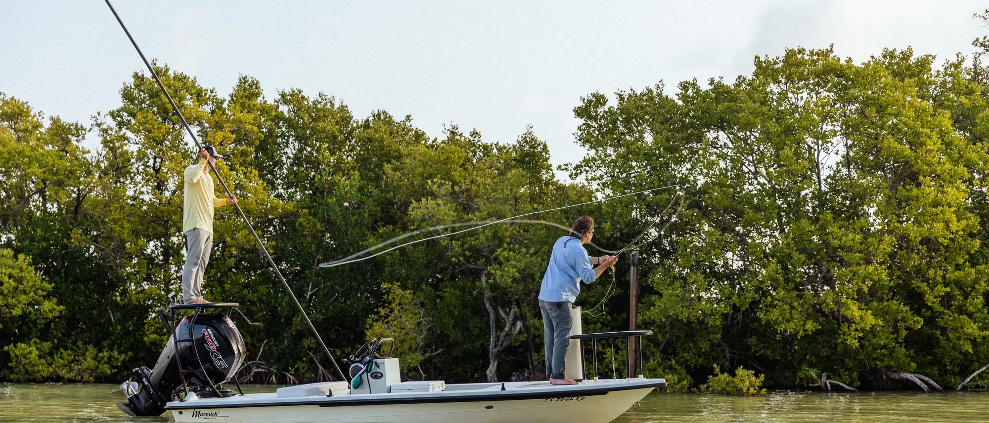 Angler on the deck at first light, rod fully loaded, fish on
