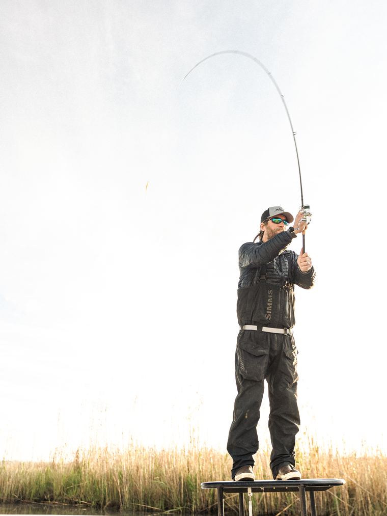 Fly line loop mid–cast, backlit over water